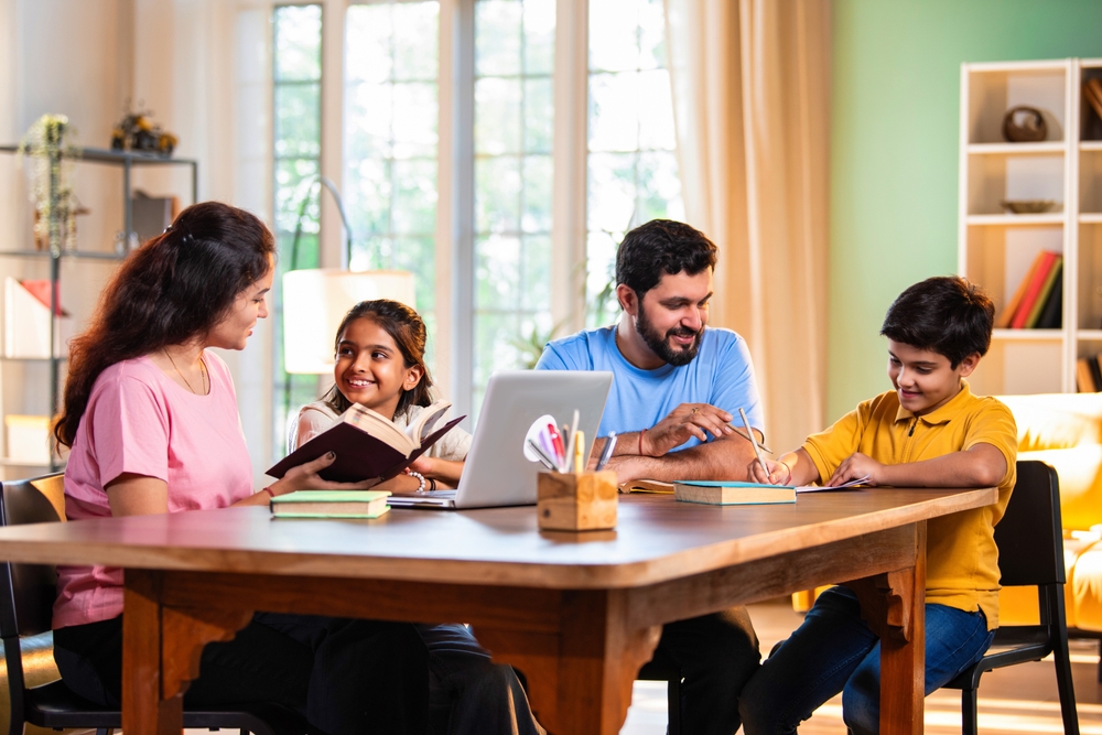 Family around table studying school work together.