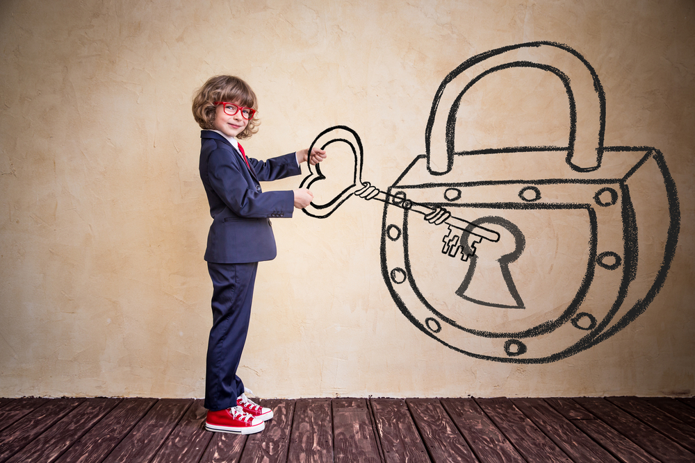 Child with large key unlocking from shutterstock.com